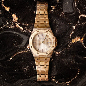 Discover the Audemars Piguet Royal Oak in rose gold — captured against a rich black marble backdrop with golden accents. Uncompromising luxury at WatchGuru NYC.